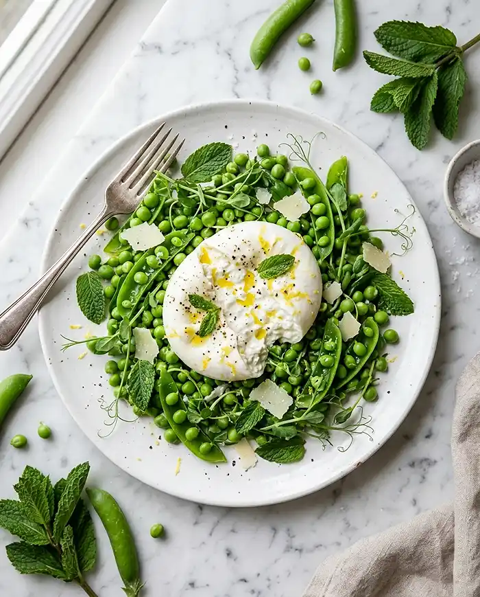 Elegant spring pea and burrata salad with fresh mint on a white plate, representing fresh St. Patrick's Day Week ideas for entertaining